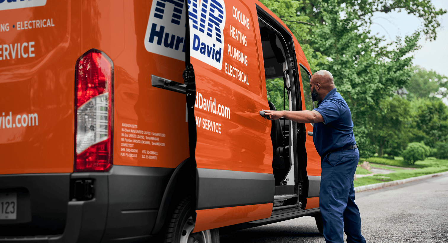A professional HD Air technician opening a service van on a residential street, ready to provide home HVAC, plumbing, and electrical services.